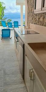 uma cozinha com um balcão com cadeiras azuis num pátio em Kuća za odmor u blizini Splita em Jesenice