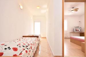um quarto com uma cama com flores vermelhas em Kuća za odmor u blizini Splita em Jesenice