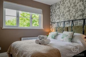a bedroom with a bed with towels on it at Guest Homes - Hales Orchard in Worcester