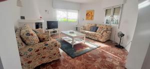 Sala de estar con 2 sofás y mesa en Villa Marbesa Beach, en Marbella