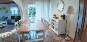 a dining room with a table and chairs and a living room at Villa Marbesa Beach in Marbella