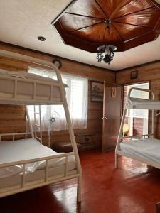 a room with two bunk beds and a ceiling at Hotspring Resort with Videoke in Calamba
