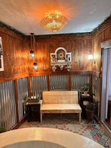 Hotspring Resort with Videoke في كالامبا: غرفة خشبية مع كرسي وثريا
