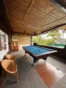 een kamer met een pooltafel en 2 stoelen bij Hotspring Resort with Videoke in Calamba