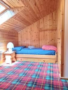 1 dormitorio con 1 cama en una cabaña de madera en La finestra sulle Dolomiti, en Carano