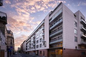 un gran edificio blanco en una calle de la ciudad en Residence Inn by Marriott Paris Didot Montparnasse, en París