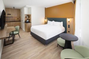 ein Hotelzimmer mit einem Bett, einem Tisch und Stühlen in der Unterkunft Residence Inn by Marriott Paris Didot Montparnasse in Paris