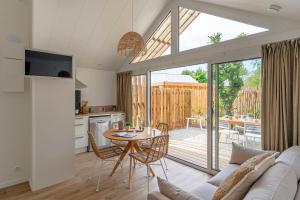 a kitchen and a living room with a table and chairs at Camping La Forêt in Saint-Jean-de-Monts