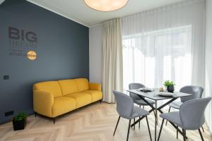 salon z żółtą kanapą i stołem w obiekcie Rare Apartments - Self Check-In Microapartments w mieście Tartu