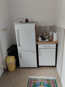 eine Küche mit einem weißen Kühlschrank und einem Tisch in der Unterkunft Sejmen in Sarajevo