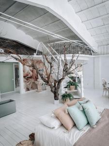 Habitación con sofá con almohadas y árbol en Suite con Jacuzzi, en Canyelles
