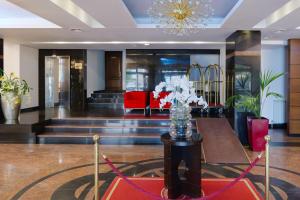 a lobby with a vase of flowers on a table at Hotel Pietroasa in Buzau