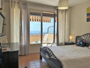 a bedroom with a bed and a view of a balcony at Bormes-les-Mimosas: Appt climatisé, 5 couchages, parking, grande terrasse - FR-1-251-136 in Bormes-les-Mimosas