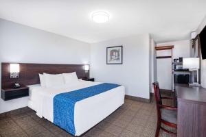 a hotel room with a large bed and a chair at Travelodge by Wyndham Newport in Newport