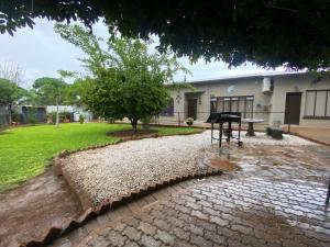 a park with a bench and a table in front of a building at El-Kole Bed and Breakfast in Tsumeb