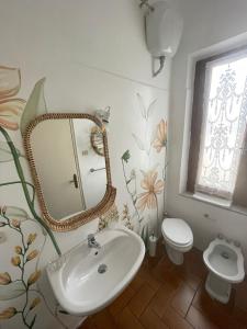 a bathroom with a sink and a mirror and a toilet at Villa Remignoli in San Gimignano