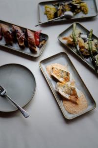 una mesa con tres platos de comida. en Holzhotel Forsthofalm, en Leogang