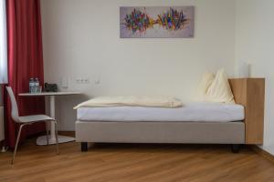 1 dormitorio con 1 cama, 1 mesa y 1 silla en Hotel Sommerhaus Linz, en Linz