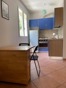 uma cozinha com armários azuis e uma mesa e cadeiras de madeira em Careggi apartment em Florença