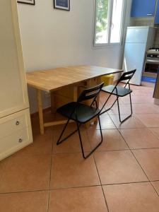 uma cozinha com uma mesa de madeira e 2 cadeiras em Careggi apartment em Florença