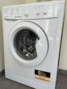 uma máquina de lavar roupa branca sentada num quarto em Careggi apartment em Florença