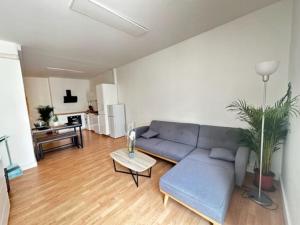 ein Wohnzimmer mit einem blauen Sofa und einem Tisch in der Unterkunft Gare/comédie 6 personne neuf in Montpellier