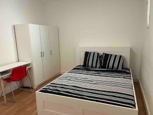 Schlafzimmer mit einem schwarzen und weißen Bett und einem Schreibtisch in der Unterkunft Gare/comédie 6 personne neuf in Montpellier