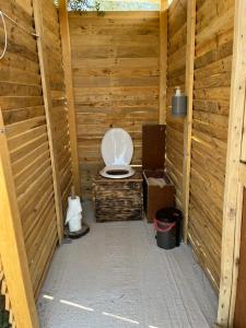 a bathroom with a toilet in a wooden stall at Eco Glamping with Pool between Nafplio and Argos in Argos