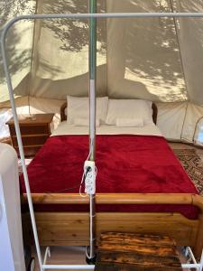 a bed in a tent with a red blanket at Eco Glamping with Pool between Nafplio and Argos in Argos
