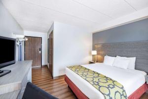 um quarto de hotel com uma cama e uma televisão de ecrã plano em Baymont by Wyndham Gillette em Gillette