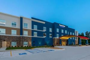 a hotel with a blue building with a parking lot at AmericInn by Wyndham Mountain Home in Mountain Home