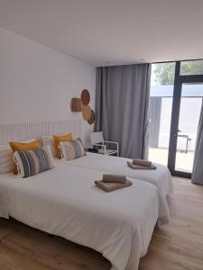 1 dormitorio con 1 cama blanca grande y toallas. en Chez Oti, en Puerto Rico de Gran Canaria