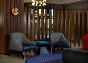 a lobby with two chairs and a couch at Hilton Kansas City Country Club Plaza in Kansas City