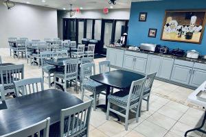 une salle à manger avec des tables et des chaises dans un restaurant dans l'établissement Baymont Inn and Suites by Wyndham Farmington, MO, à Farmington