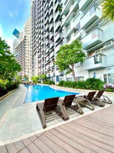 una piscina con sillas y un edificio en Frost at Manhattan Heights TowerB en Manila