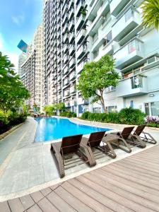 a swimming pool with chairs and a building at Frost at Manhattan Heights TowerB in Manila
