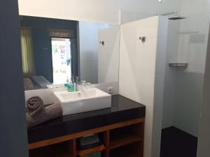 ein Badezimmer mit einem weißen Waschbecken und einem Spiegel in der Unterkunft Rasti 2 homestay in Kuta Lombok
