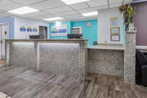a lobby of a dental office with a reception counter at Travelodge by Wyndham Livonia Canton Novi Detroit Area in Livonia