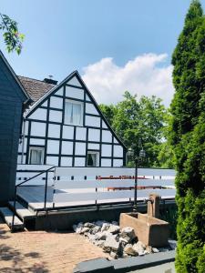 a black and white house with a bench in front of it at Haus Oberkirchen in Schmallenberg