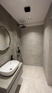 Un baño con un lavabo blanco y un espejo. en Amber Home - brand NEW luxury 1 bedroom apartment located in the very city center, en Varna