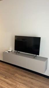 TV de pantalla plana en un centro de entretenimiento blanco en Amber Home - brand NEW luxury 1 bedroom apartment located in the very city center, en Varna