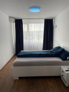 um quarto com uma cama com um cobertor azul e uma janela em Regim Hotelier DEVA, str. Mihai Viteazu, bl. RESIDENCE !!! em Deva