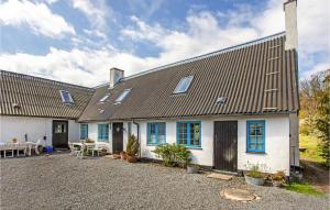 a white house with blue windows and a patio at Lovely Apartment In Gudhjem With Kitchen in Gudhjem