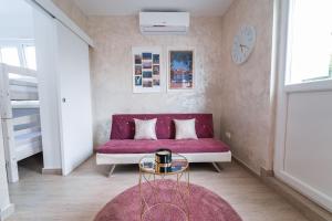 a living room with a red couch and a table at Studio apartment with garden at Split suburbs in Stobreč