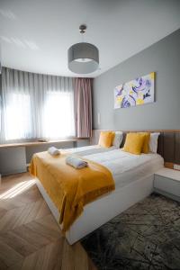 a bedroom with a large bed with yellow sheets at VILA MILAGO l Baile Felix l ORADEA l Jacuzzi & Sauna in Baile Felix