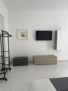 a living room with a tv on a white wall at Casaurora Centro Storico in Catania