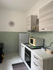 a kitchen with a microwave and a refrigerator at Casaurora Centro Storico in Catania +15 photos