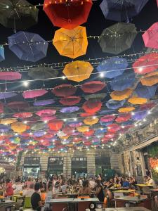 a group of people sitting at tables under umbrellas at Casaurora Centro Storico in Catania