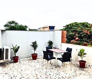 une table et des chaises sur une terrasse agrémentée de plantes dans l'établissement Otel, à Nagpur