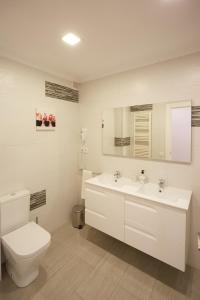 Baño blanco con aseo y lavamanos en Apartamento Turístico VIANA II, en Viana